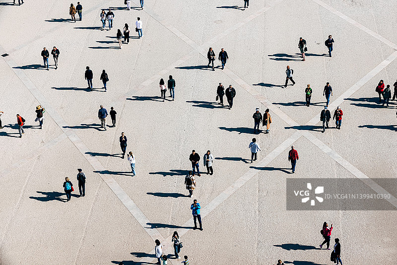 阳光明媚的日子里城市广场上人群的航拍图片素材
