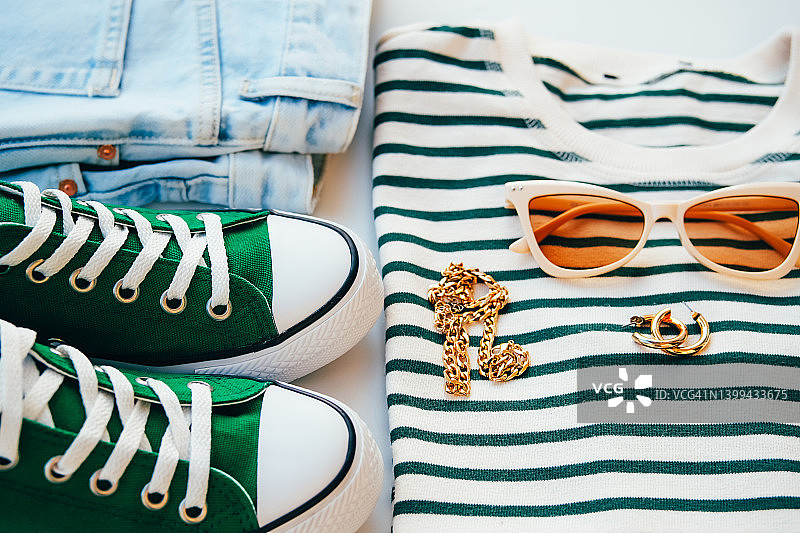 基础服装时尚搭配。牛仔裤、运动鞋、条纹衬衫和配饰。平铺，俯视图。图片素材
