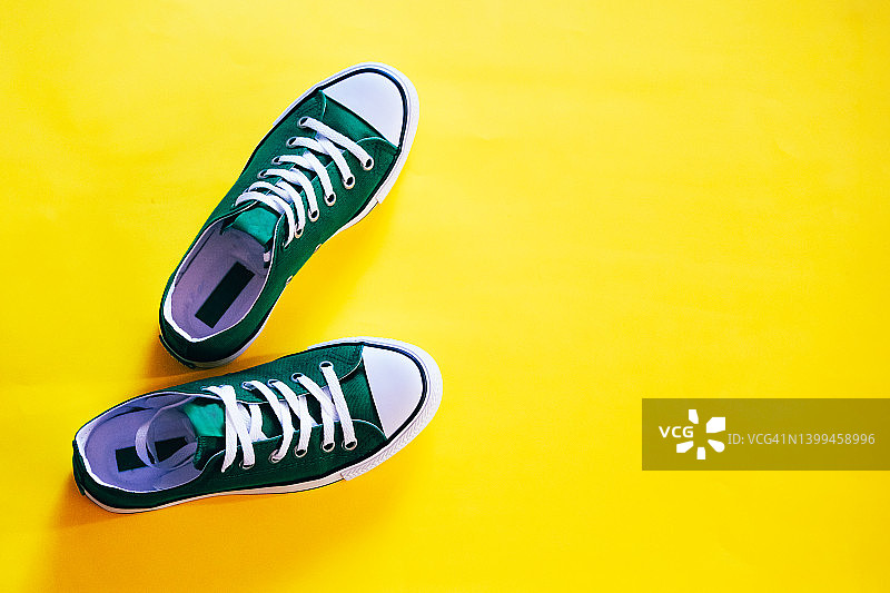 黄色背景上的运动鞋图片素材