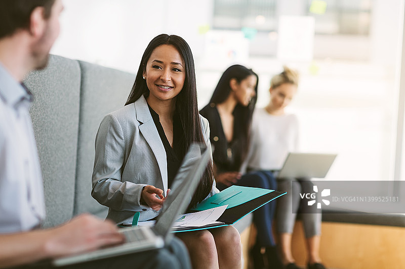 不同种族的年轻女性在现代共享办公室内与同事讨论工作计划和想法图片素材