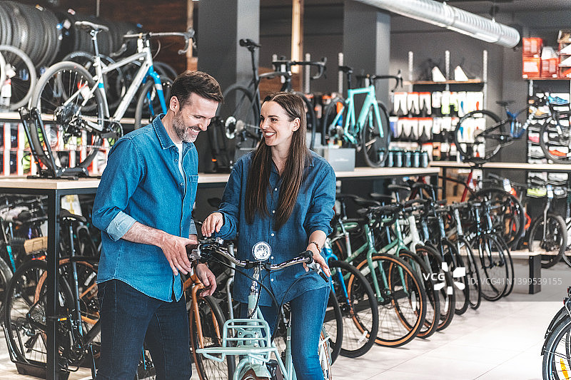男人在自行车店向女顾客展示新款电动自行车图片素材