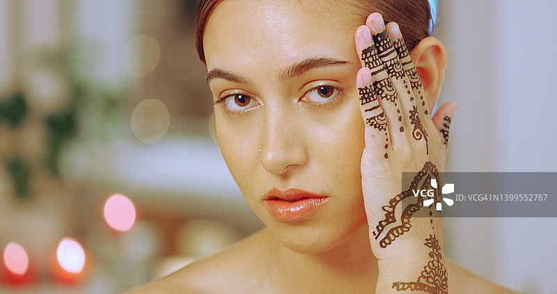 在水疗中心展示手上的曼海蒂或海娜纹身的女人。一位年轻女士在豪华健康水疗中心享受轻松美容和健康的一天图片素材