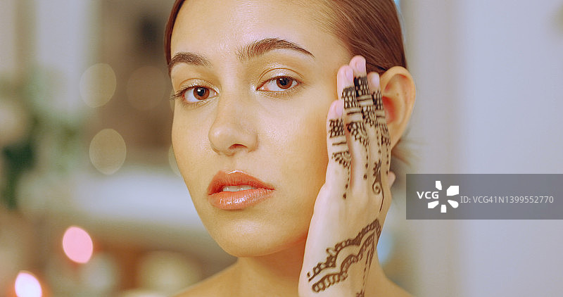 在水疗中心展示手上的曼海蒂或海娜纹身的女人。一位年轻女士在豪华健康水疗中心享受轻松美容和健康的一天图片素材