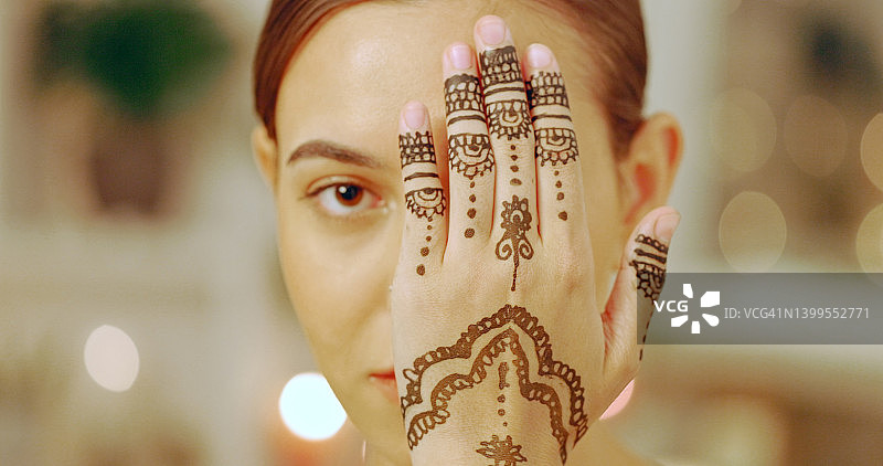 在水疗中心展示手上的曼海蒂或海娜纹身的女人。一位年轻女士在豪华健康水疗中心享受轻松美容和健康的一天图片素材