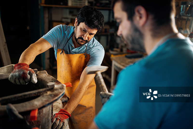 小型企业 - 车间制造，工人打开装满混凝土和水泥的模具图片素材