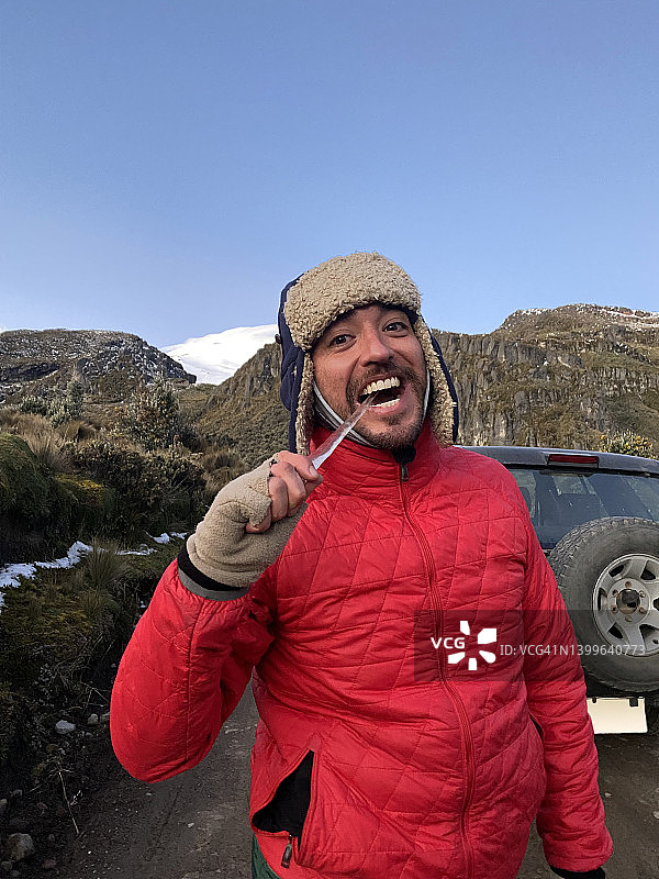 年轻帅气的拉丁裔男性背包客徒步旅行,享受在Sierra高地行走和徒步旅行的假期时光,在基多附近的正午时分,在钦博拉索火山,卡扬贝火山,科托帕希火山前,天空蔚蓝,厄瓜多尔图片素材