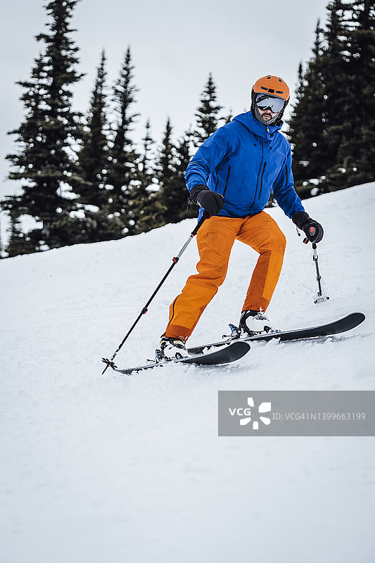 滑雪者在不列颠哥伦比亚省的滑雪道上急转弯图片素材