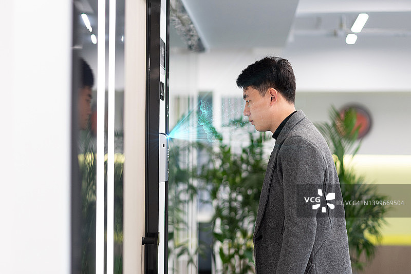 使用面部识别技术的中国年轻商人图片素材