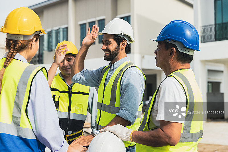 工程师讨论住房项目进展，击掌庆祝图片素材