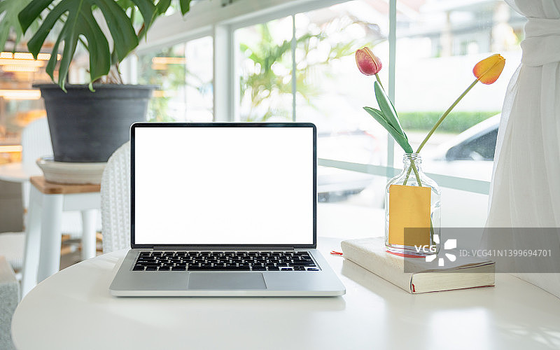 咖啡馆内桌面上带空白屏幕的笔记本电脑图片素材