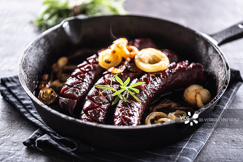 平底锅中搭配洋葱、大蒜和蘑菇的烤香肠图片素材