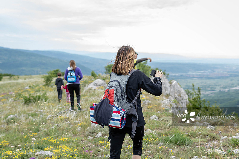 女徒步者用智能手机拍照图片素材