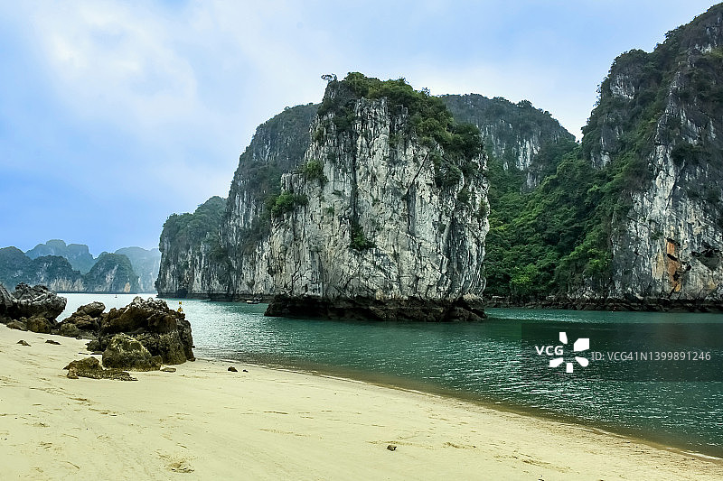 越南下龙湾的金色沙滩和石灰岩喀斯特地貌岛屿图片素材