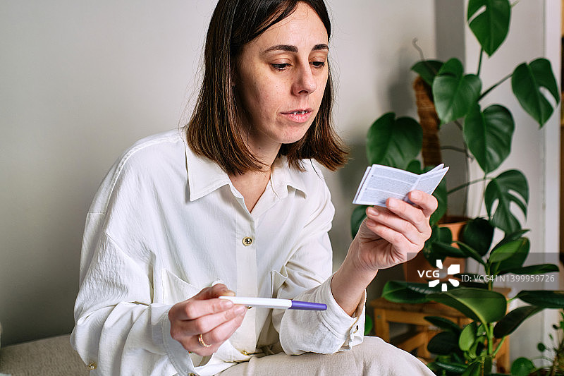 女人仔细阅读妊娠测试说明书图片素材