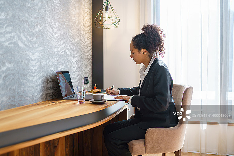 在酒店房间进行视频通话的拉美裔女商人图片素材
