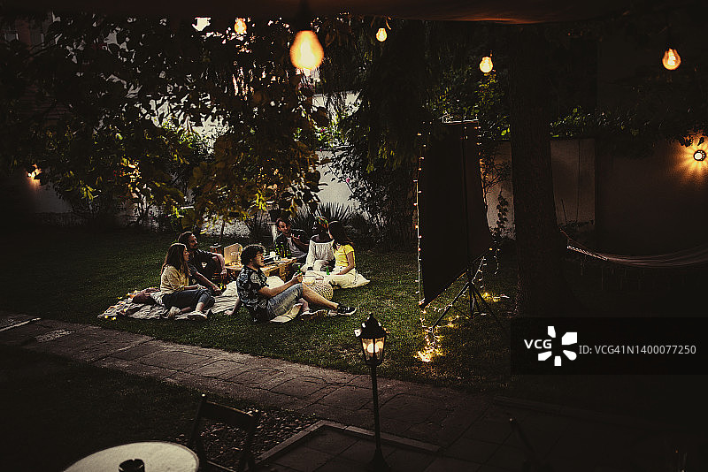 朋友们在后花园用投影仪看电影图片素材