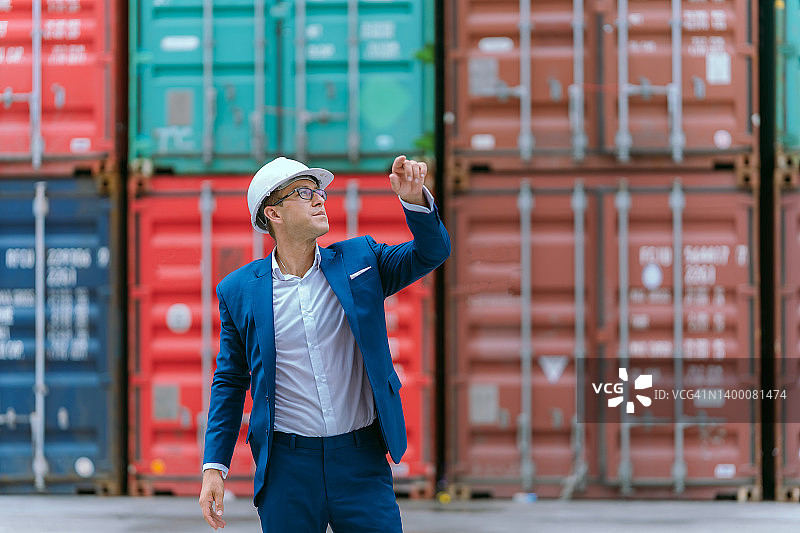 仓库中的公司高管肖像，展示国际出口集装箱的工业港口区域图片素材
