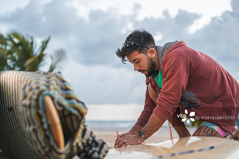 冲浪者将龙骨安装在冲浪板上图片素材