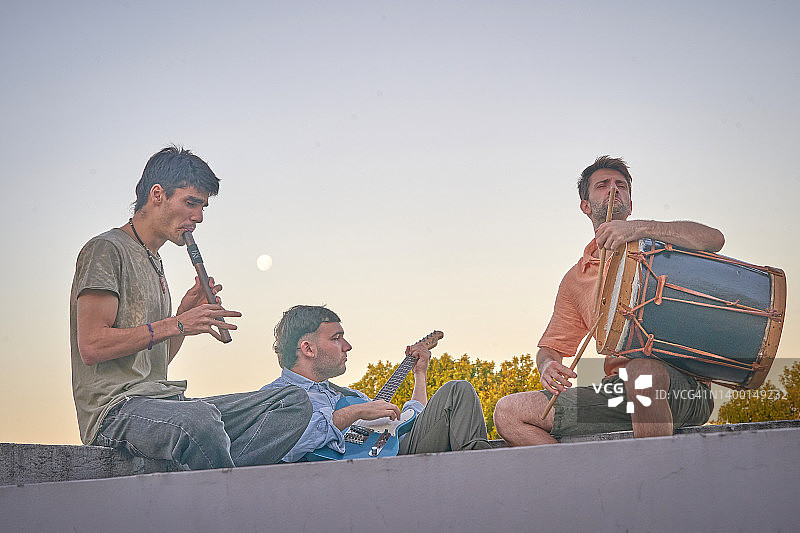 快乐的朋友们在屋顶派对上享受音乐图片素材