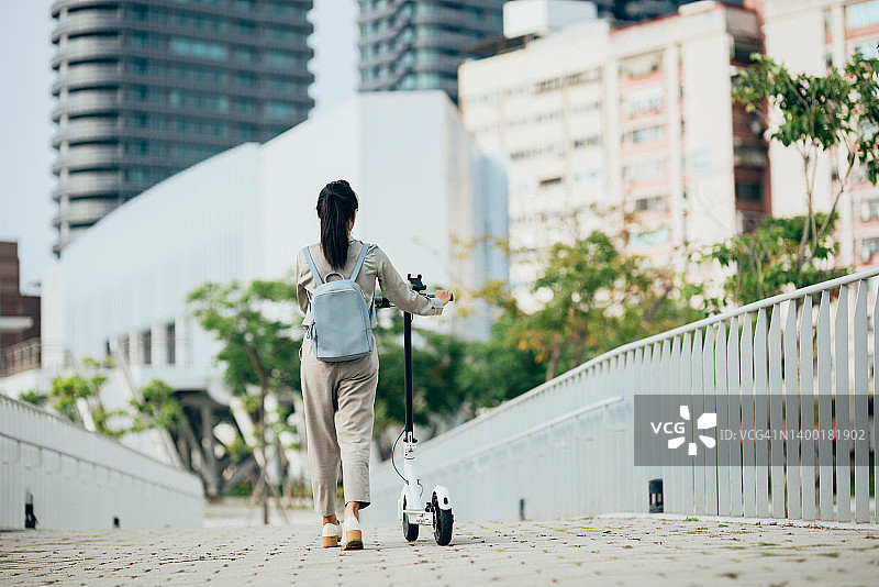 骑共享电动滑板车的年轻女子图片素材