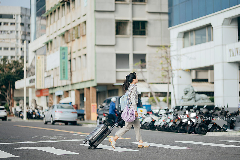 自信的商务女性拉着行李行走图片素材