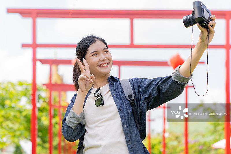 在泰国寺庙自拍的游客，为旅行视频博客录制内容图片素材