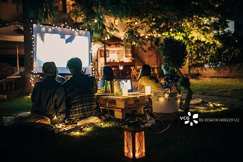 朋友们在后花园用投影仪看电影图片素材