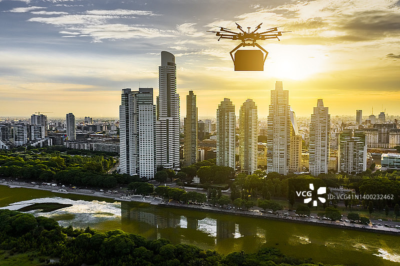 日落时分高楼大厦背景下的配送无人机图片素材
