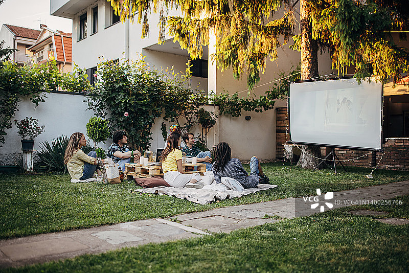 朋友们在花园里用投影仪看电影图片素材