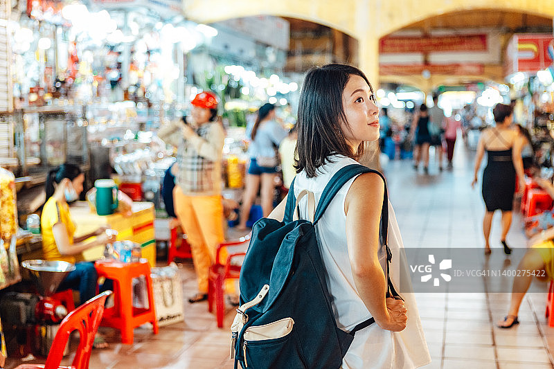 年轻女游客在越南胡志明市的当地街头食品市场行走图片素材