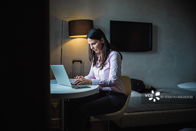 在酒店房间度假工作的女商人图片素材