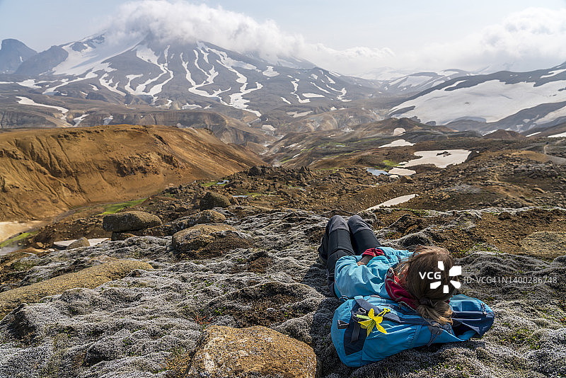 晴天，女人们躺在Hveradalir地热区的苔藓上图片素材