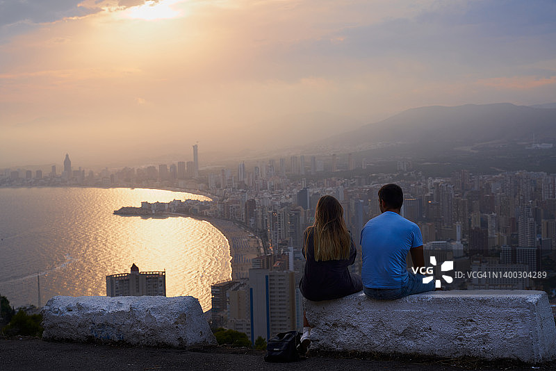 情侣观赏城市景观和海景的背影图片素材