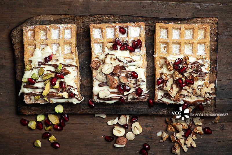 撒有巧克力和坚果的比利时糖粉华夫饼图片素材