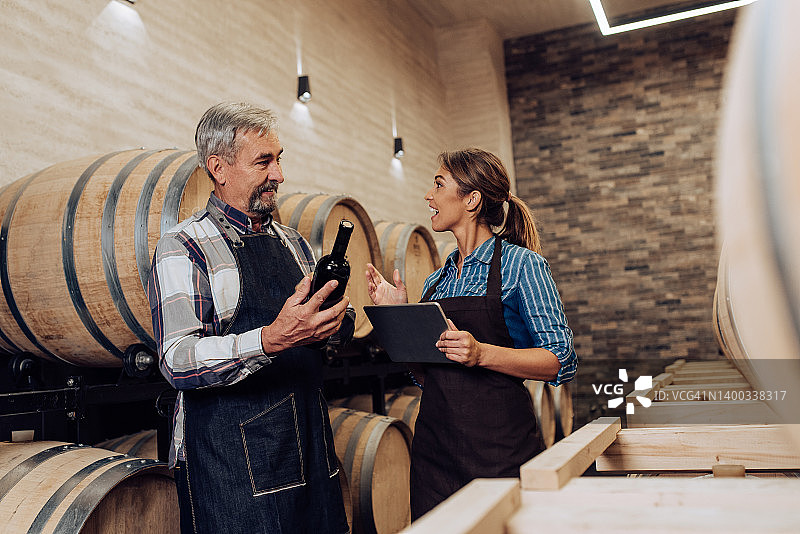 父女在家族酿酒厂检查葡萄酒的质量图片素材