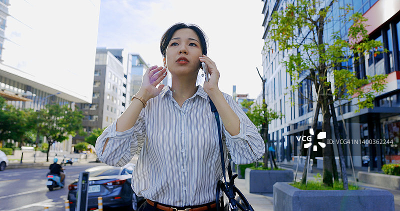 手持智能手机的自信年轻女商人肖像图片素材