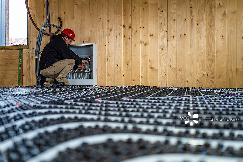 正在安装地暖系统的建筑工人图片素材