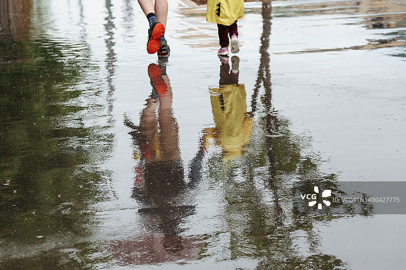 父亲和儿子雨天城市水坑倒影图片素材