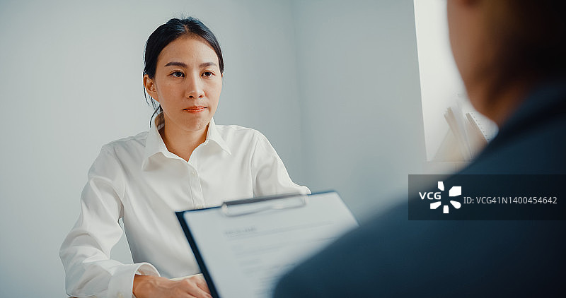 年轻女商人面试工作，同时在办公室讨论简历图片素材