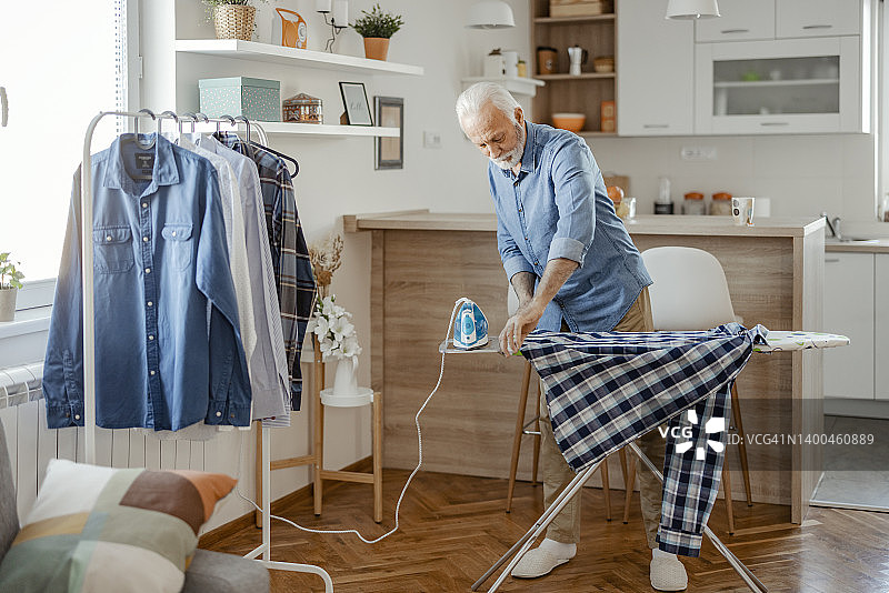 老年男人在家熨衣服图片素材