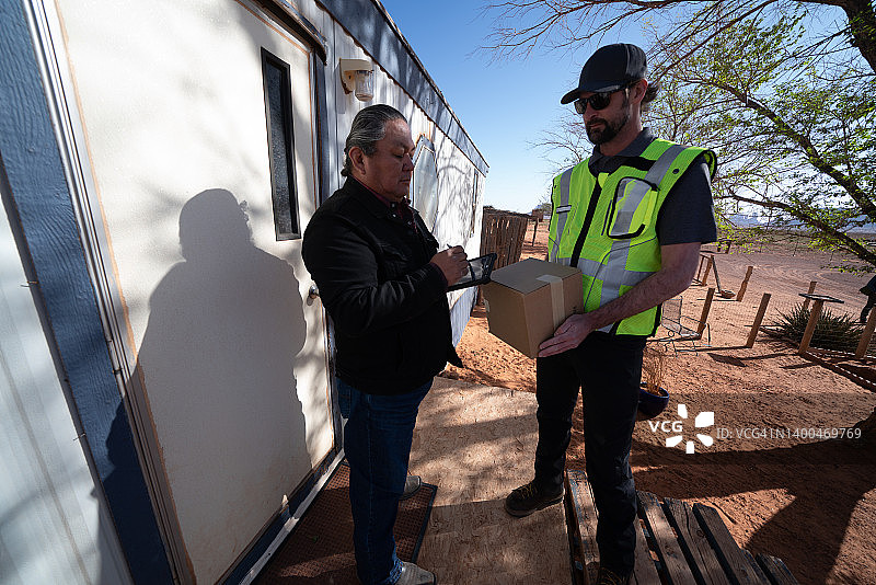 男子在小镇的组合房屋里给老年男子送包裹图片素材