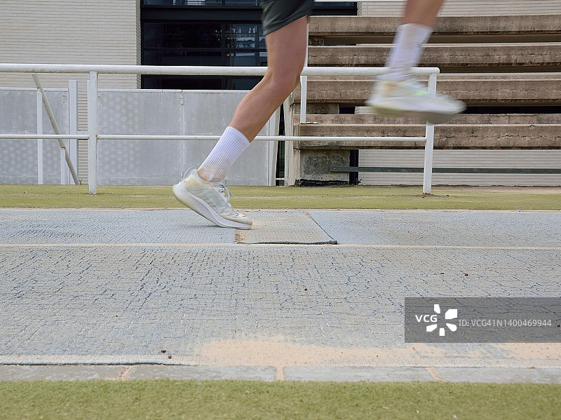 运动员在跳远跑道上跳跃图片素材
