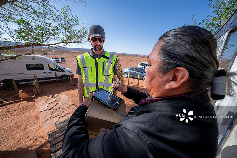 男子在小镇的组合房屋里给老年男子送包裹图片素材