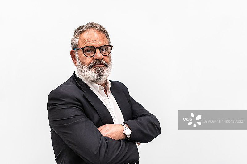 年长男商人抱臂站立的白色背景肖像图片素材