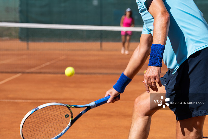 在红土球场上打网球的运动员图片素材