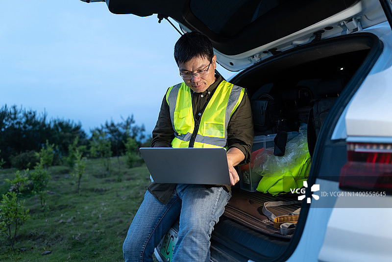 工程师深夜在车内用笔记本电脑加班图片素材