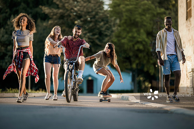 在街上玩耍的快乐千禧一代朋友图片素材
