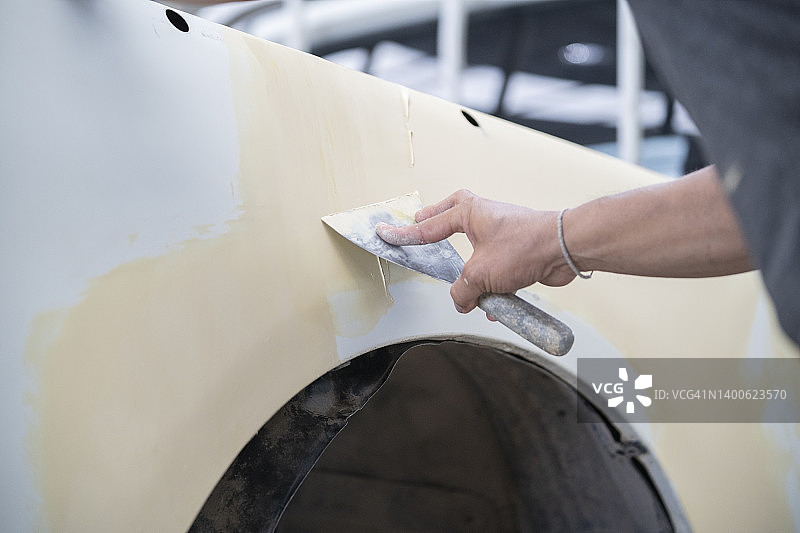 工人用腻子修复汽车油漆图片素材