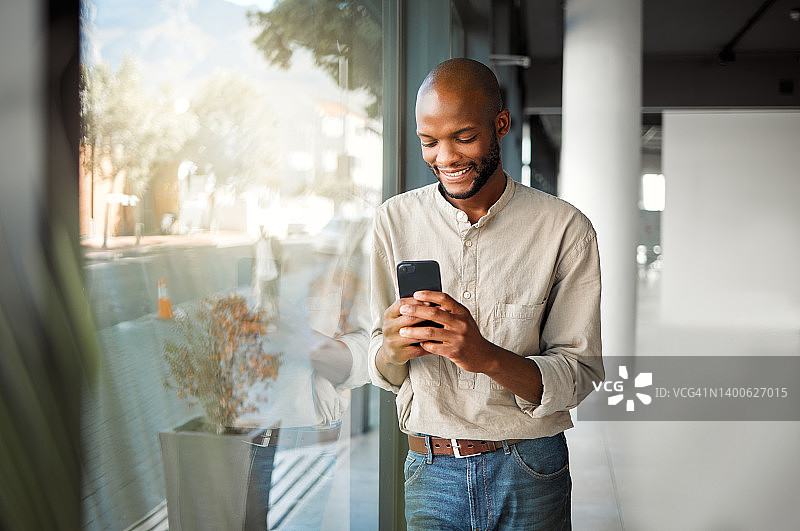 快乐的非裔美国商人工作时在手机上打字图片素材