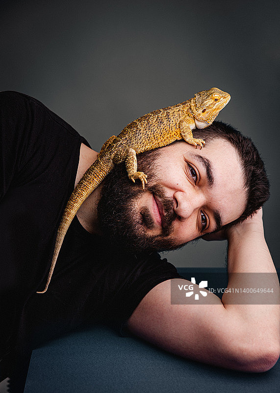 男子和他的宠物鬃狮蜥肖像图片素材